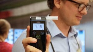 Man holding up a alcohol intoxication meter in study around drunk driving