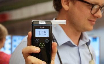 Man holding up a alcohol intoxication meter in study around drunk driving